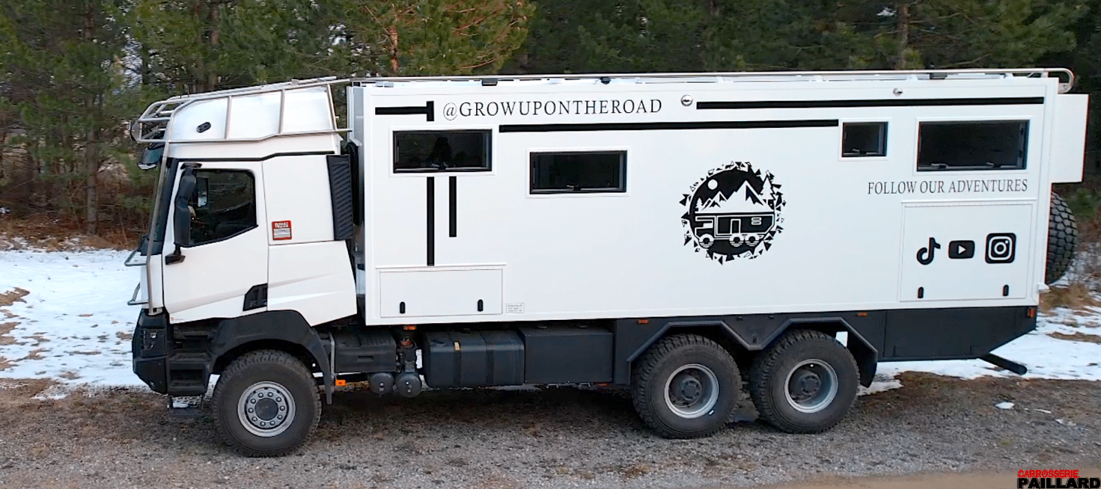 Camping-car Renault 6×6 blanc vu de profil sur un terrain enneigé
