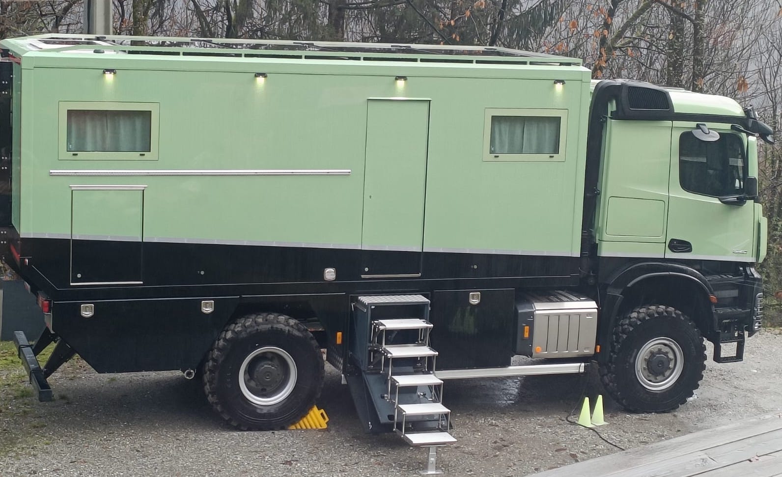Vue de profil du camping-car d’expédition Mercedes AROCS 5 2040 AKN GRDN vert et noir